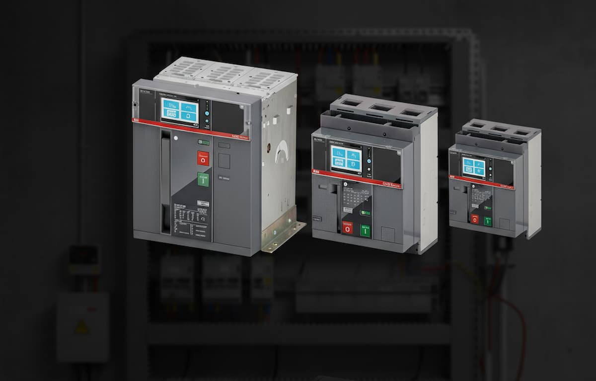 Tipos de interruptor termonmagnético en primer plano, al fondo hay una instalación eléctrica industrial.