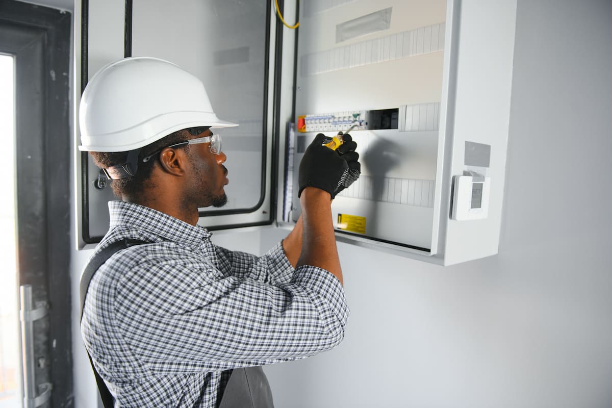 Un trabajador brinda mantenimiento a tableros eléctricos.